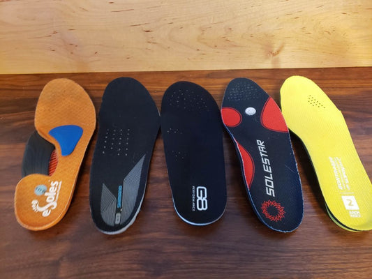 Five different cycling shoe insoles lined up in a row