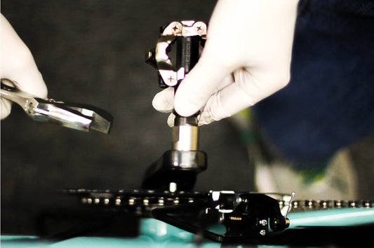 A bike mechanic installs a pedal onto a crankset